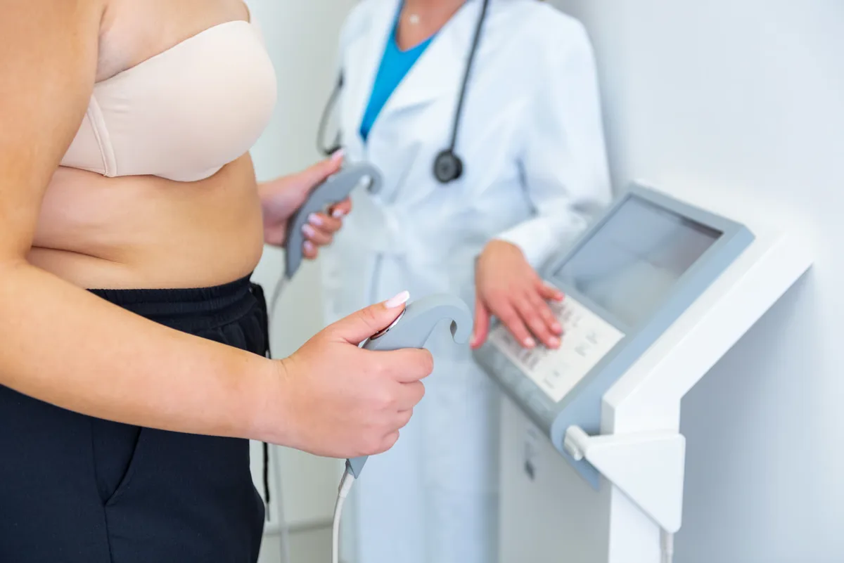 Clinician checking a patient's body composition on a scale during a consultation
